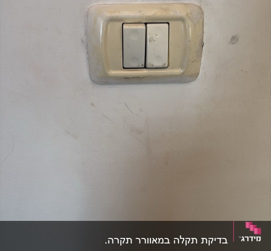 מתג חשמל על קיר לבן